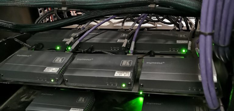 Av Control Rack Multiple converters with green LED indicators and purple cabling, clustered together.